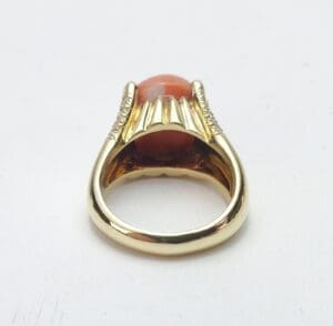 Gold ring with orange gemstone setting.