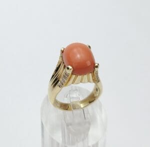 Gold ring with a large orange gemstone.
