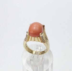 Gold ring with a coral gemstone.
