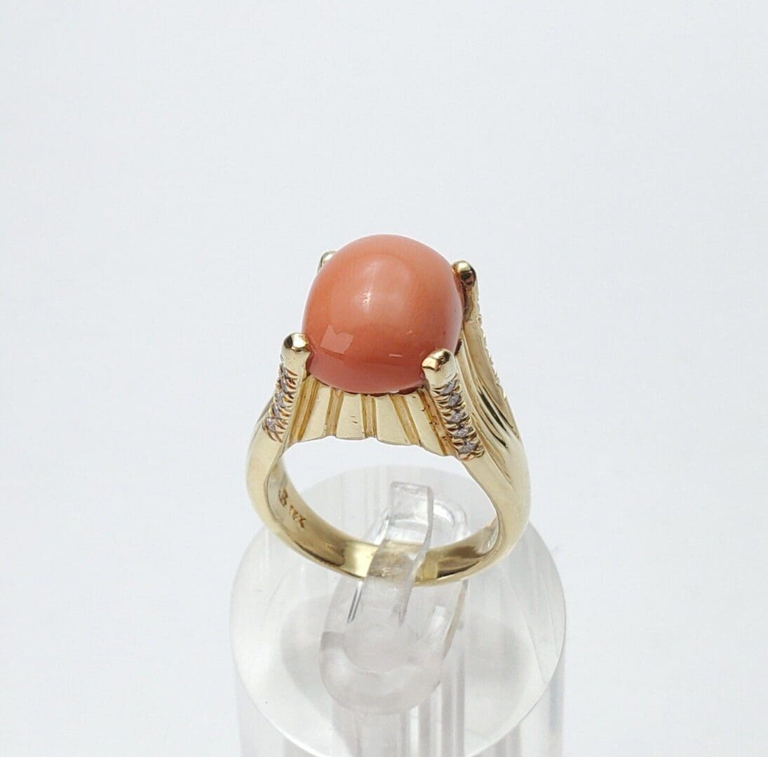 Gold ring with a coral gemstone.