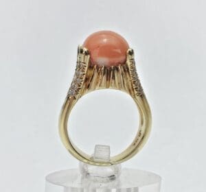 Gold ring with coral gemstone and diamonds.