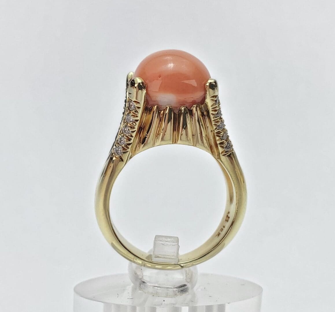 Gold ring with coral gemstone and diamonds.