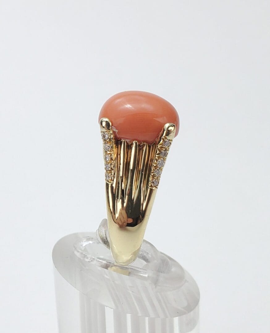 Gold ring with coral and diamonds.