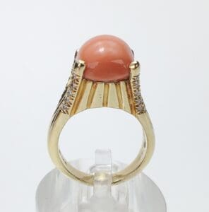 Gold ring with coral gemstone and diamonds.