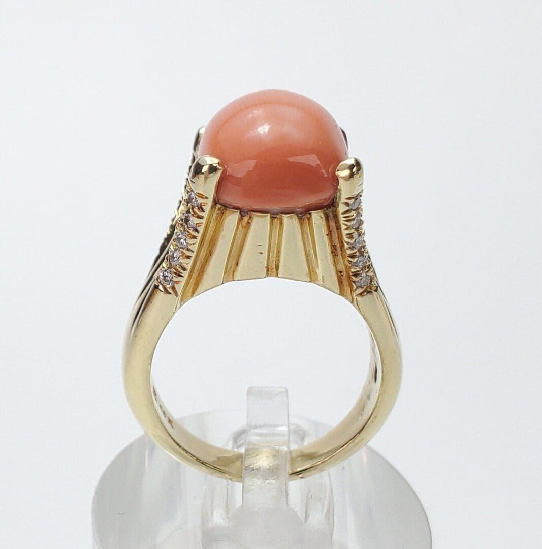 Gold ring with coral gemstone and diamonds.
