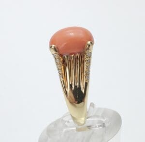 Gold ring with pink gemstone and diamonds.