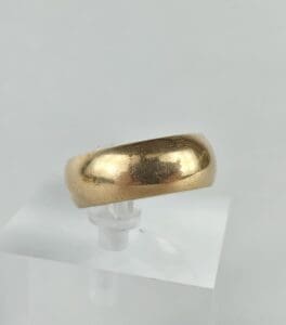 Gold ring on clear display stand.