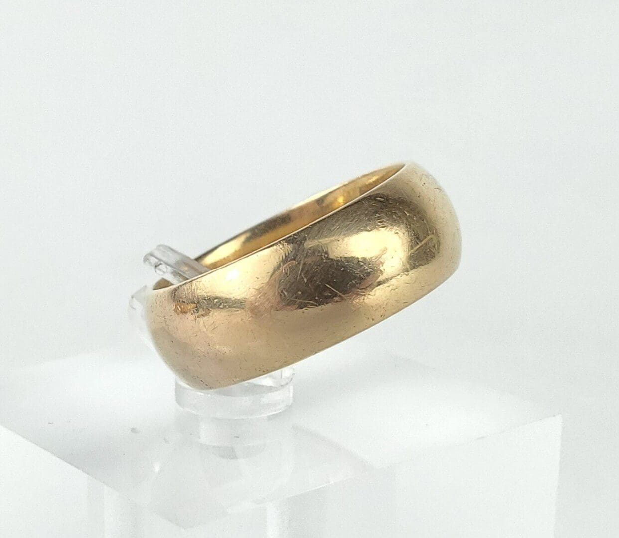 Gold ring on clear display stand.