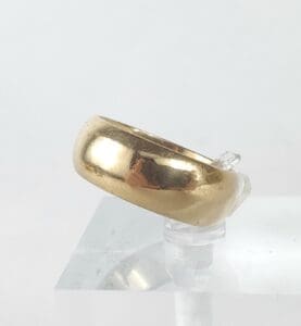 Gold ring on a clear display stand.