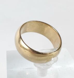 Gold ring on clear display stand.