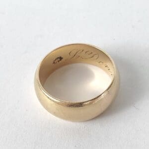 Gold ring with engraved interior inscription.