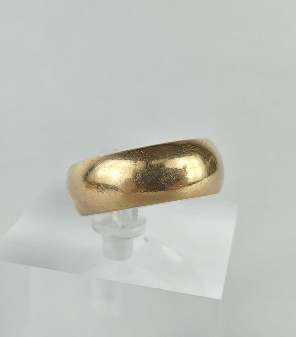 Gold ring on clear display stand.