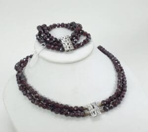 Dark beaded necklace and bracelet on display.