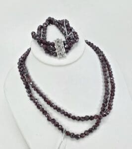 Dark beaded necklace and bracelet on display.