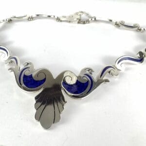 Silver necklace with blue enamel accents.