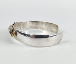 Silver cuff bracelet with decorative accents.