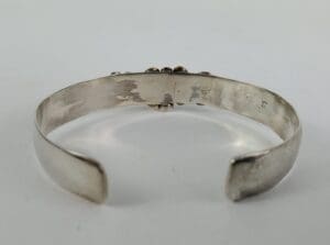Silver cuff bracelet with textured surface.