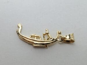 Gold boat pendant with two figures.