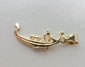 Gold lizard-shaped pendant on white background.