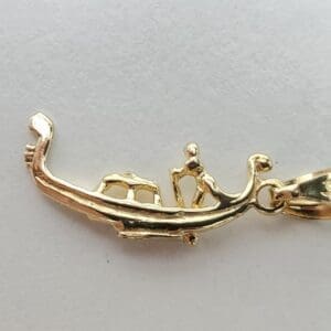Gold lizard-shaped pendant on white background.
