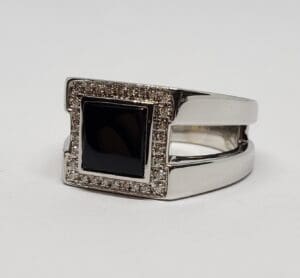 Silver ring with black square gemstone.