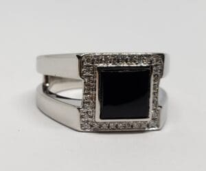 Silver ring with black stone and diamonds.