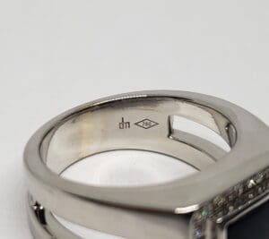 Silver ring with diamond and hallmark engraving.