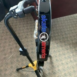 Bicycle wheel on repair stand, Skate America logo.