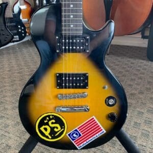 Electric guitar with stickers on body.
