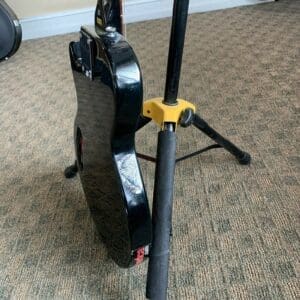 Black electric guitar on a stand.