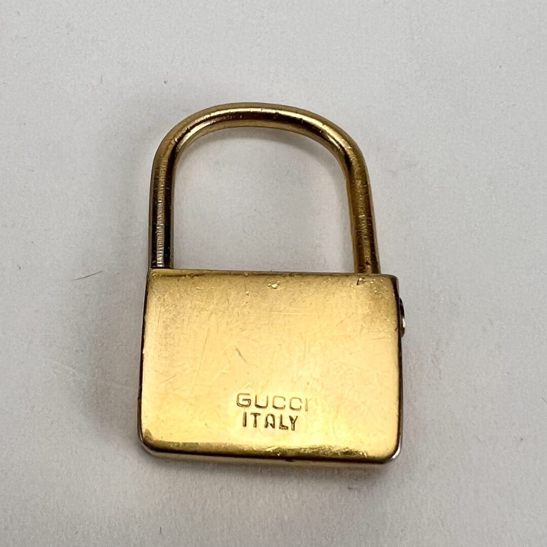 Gold padlock engraved with Gucci Italy.