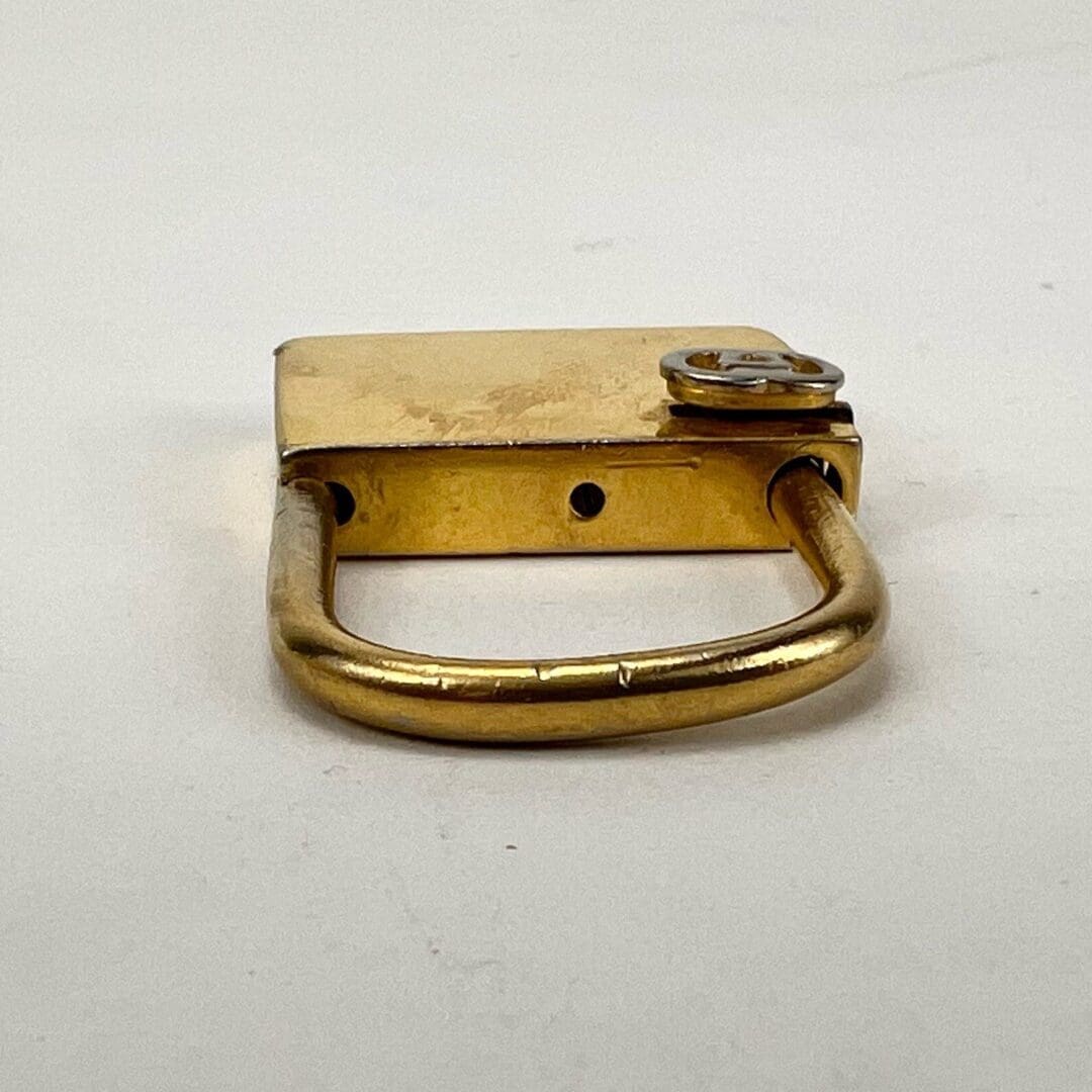 Golden padlock lying on a surface.