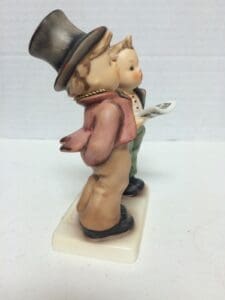 Two figurines, one holding a newspaper.
