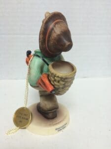 Figurine of child with basket and hat.
