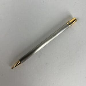 Silver pen with gold accents on paper.