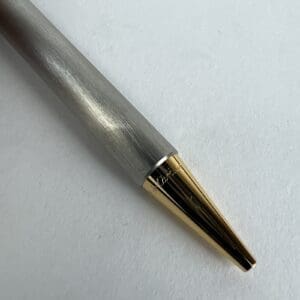 Silver pen with gold tip on paper.