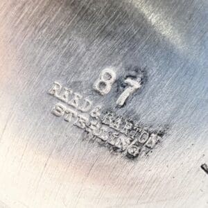 Sterling silver stamp with number and text.