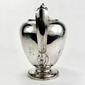 Silver teapot with elegant curved handle.