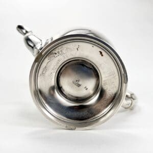 Bottom view of a silver teapot.