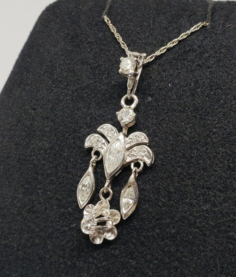 Ornate silver necklace with floral pendant design.