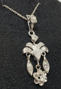 Elegant silver pendant with intricate floral design.