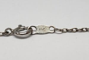 Silver necklace clasp with "14K" marking.