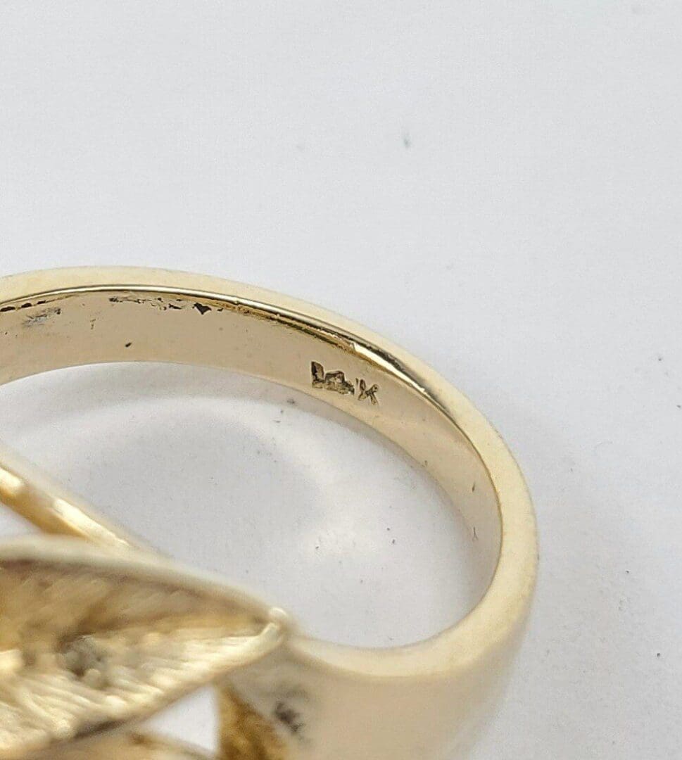 Gold ring with engraved hallmark inside band.