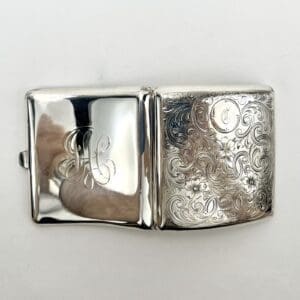 Engraved silver cigarette case with initials.
