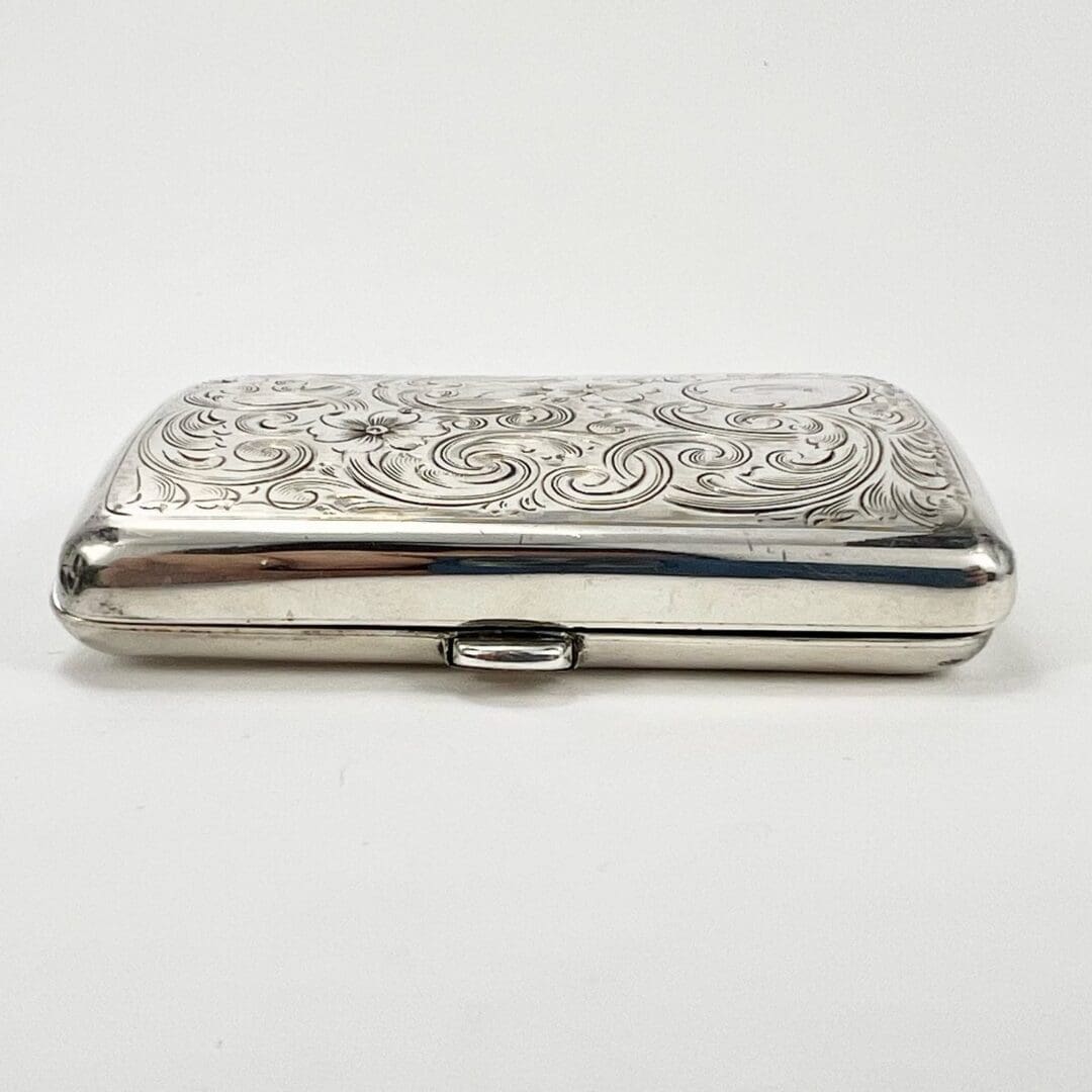 Ornate silver cigarette case with engravings.