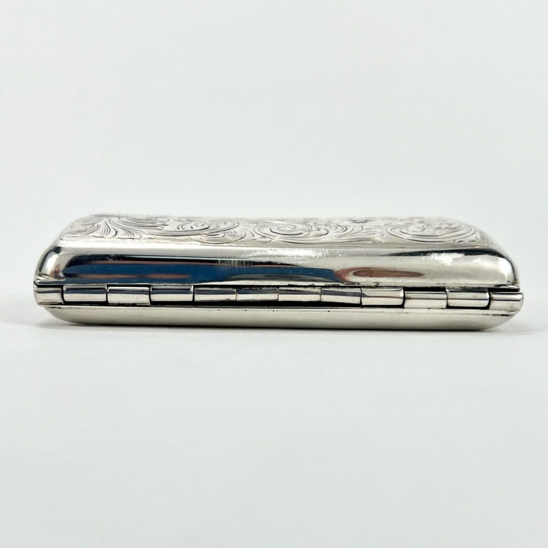 Ornate silver case with floral engraving.