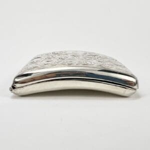 Silver decorative metal case with embossed design.