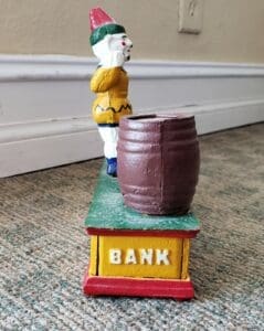 Vintage clown bank with barrel mechanism.