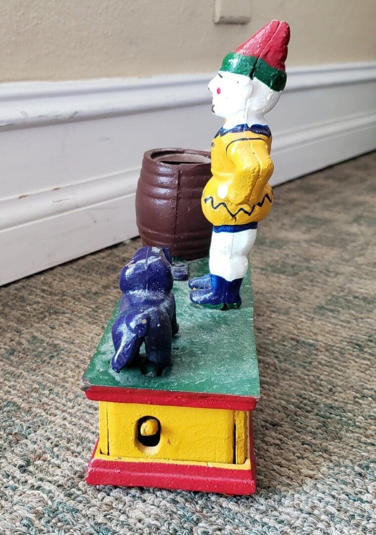 Vintage mechanical toy with clown and dog.