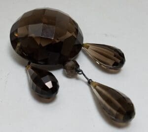 Faceted brown gemstone with three teardrop pendants.